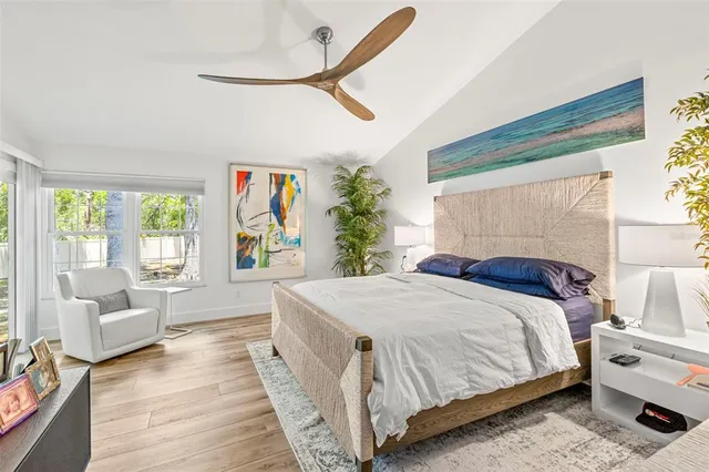 a bedroom with a large bed and a potted plant