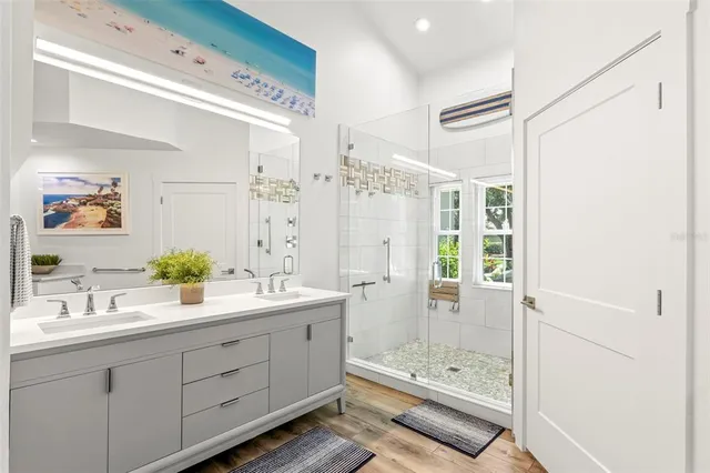 a bathroom with a granite countertop sink a large mirror and shower