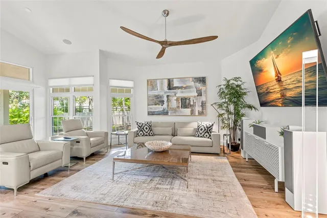 a living room with furniture a flat screen tv and a large window