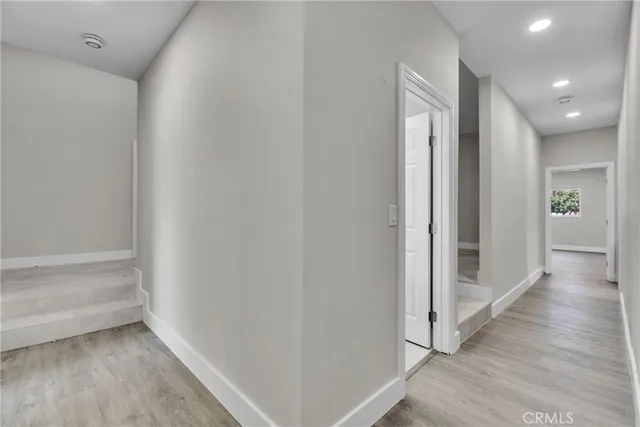 a view of a hallway with wooden floor