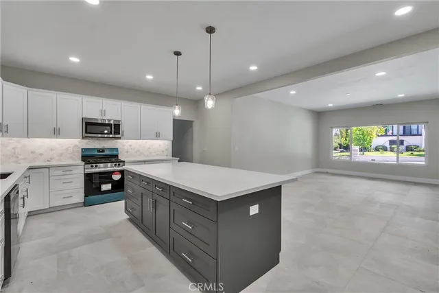 a kitchen with a stove a refrigerator and a microwave