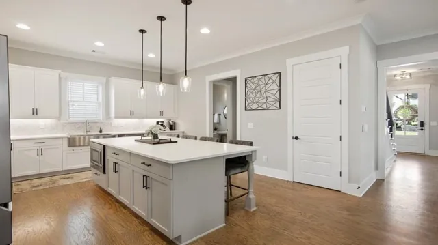 a spacious bedroom with a bed a chandelier and a dresser