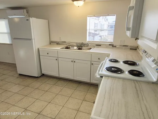a kitchen with a refrigerator a stove a sink and a window