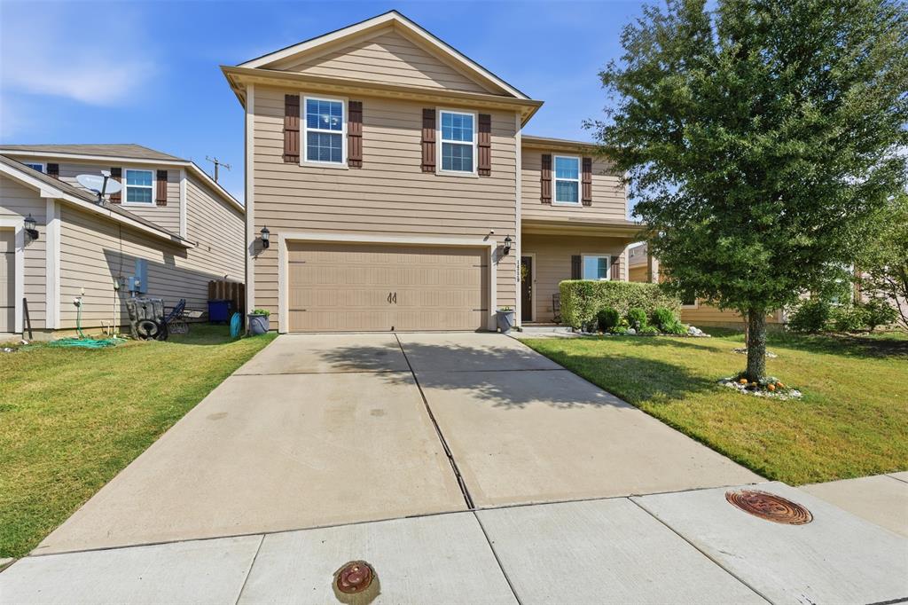 a front view of a house with a yard and trees