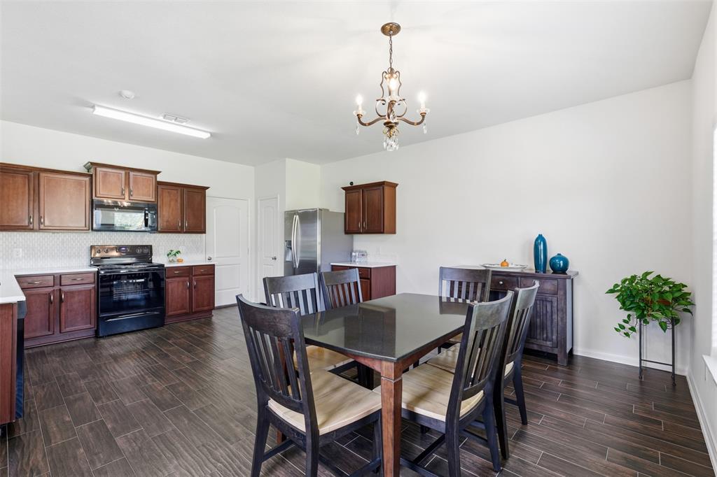 14229 Bridgeview Lane Dallas, TX 75253 - Photo 11 of 29 a view of a dining room with furniture a chandelier and wooden floor