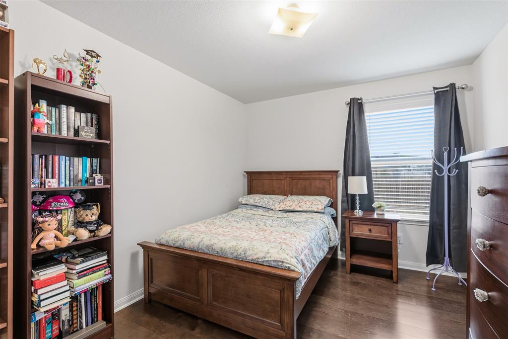 14229 Bridgeview Lane Dallas, TX 75253 - Photo 17 of 29 a bedroom with a bed and a book shelf