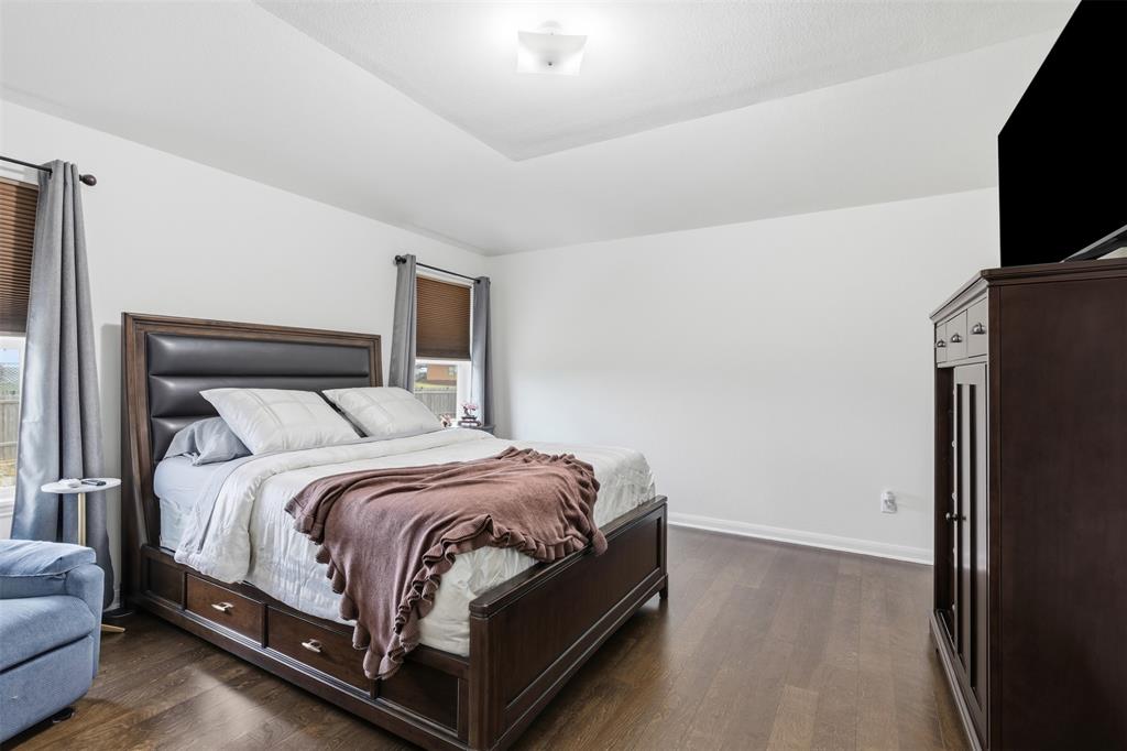 14229 Bridgeview Lane Dallas, TX 75253 - Photo 18 of 29 a bedroom with a bed flat screen tv and a couch