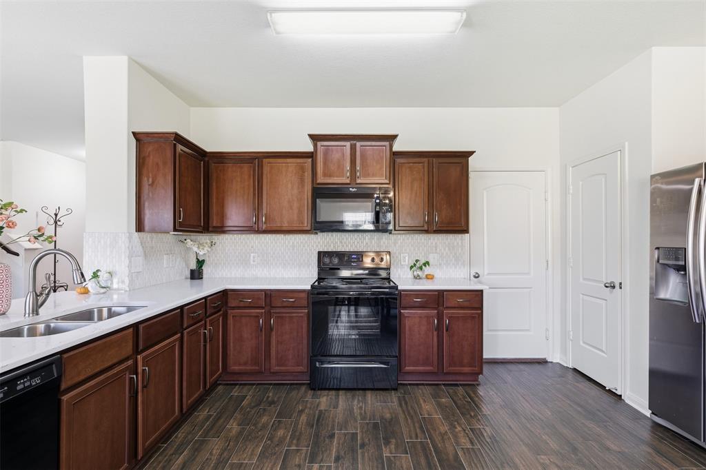 14229 Bridgeview Lane Dallas, TX 75253 - Photo 9 of 29 a kitchen with stainless steel appliances granite countertop wooden cabinets a stove a sink and dishwasher with wooden floor