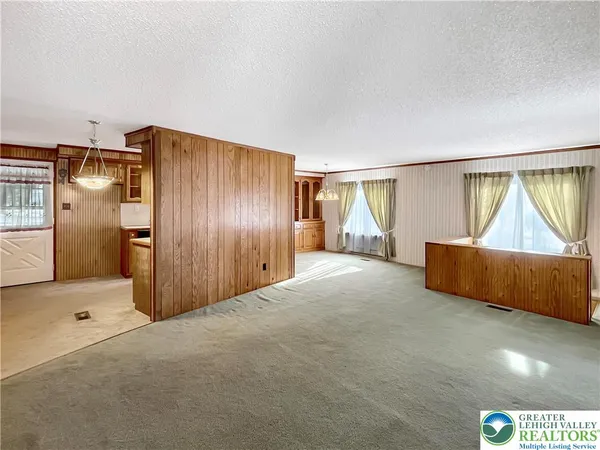 a view of an empty room with window and cabinet