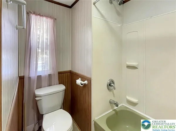 a white toilet sitting next to a bathroom sink and tub