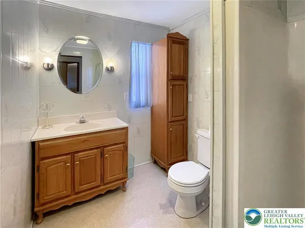 a bathroom with a toilet a sink a vanity and mirror