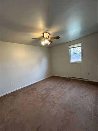 an empty room with a ceiling fan and window