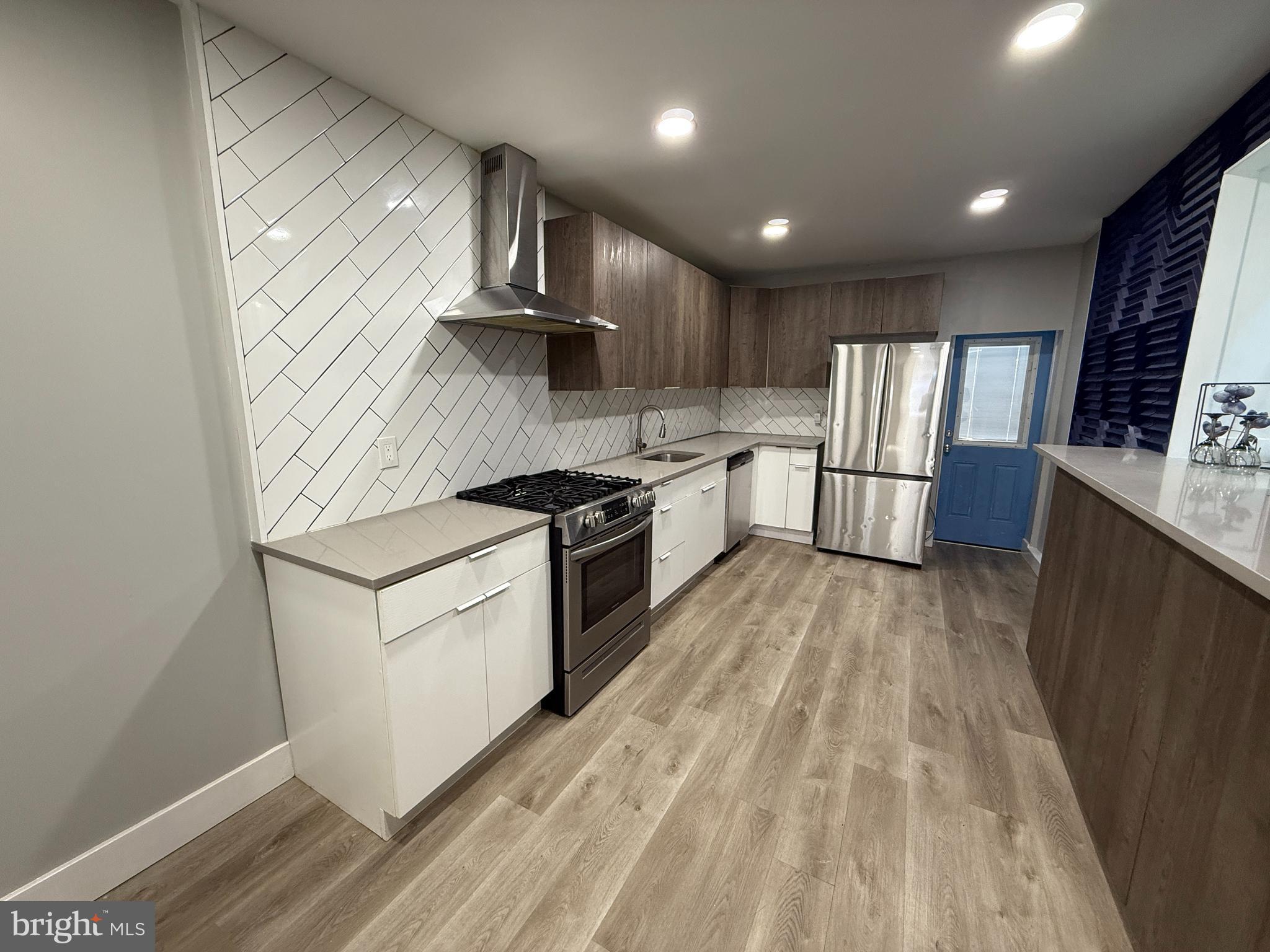 2943 Wharton Street Philadelphia, PA 19146 - Photo 10 of 36 a kitchen with stainless steel appliances sink stove refrigerator and wooden floor