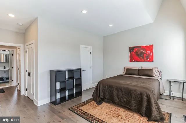 a bedroom with a bed and wooden floor
