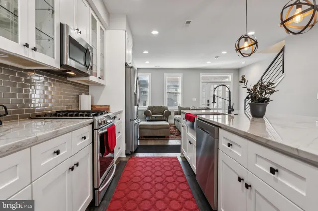 a kitchen with stainless steel appliances granite countertop a sink and dishwasher a stove top oven with wooden floor