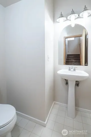 a bathroom with a toilet a sink and mirror