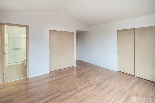 an empty room with wooden floor & closet area