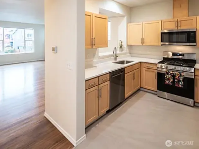 a kitchen with stainless steel appliances granite countertop a stove a sink and a microwave