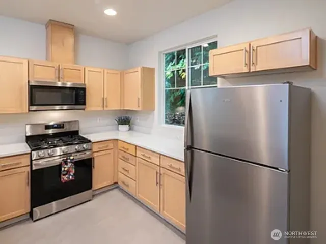 a kitchen with stainless steel appliances a refrigerator sink and microwave