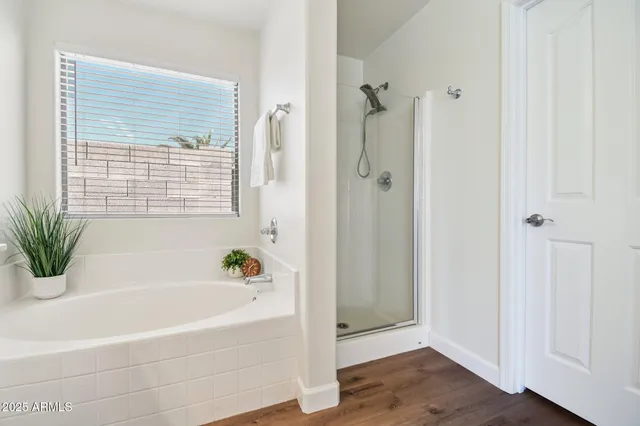 a spacious bathroom with a double vanity sink a mirror and a shower