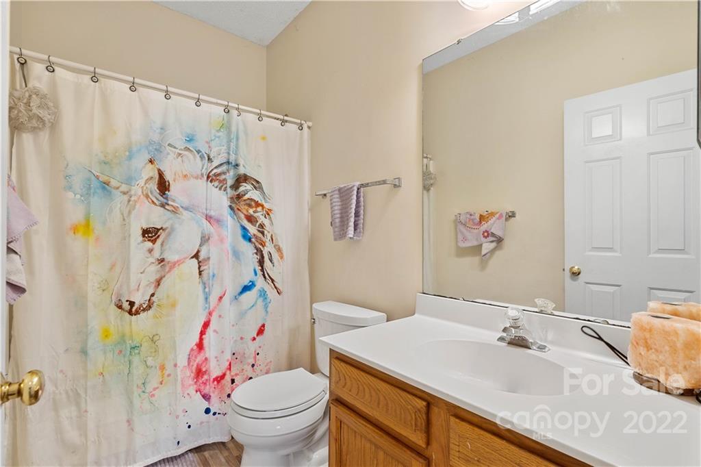 7001 Reedy Creek Road Charlotte, NC 28215 - Photo 13 of 24 a bathroom with a granite countertop sink and a mirror