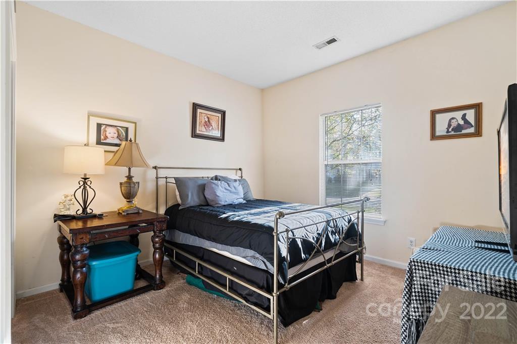 7001 Reedy Creek Road Charlotte, NC 28215 - Photo 16 of 24 a bedroom with a bed and a lamp on table