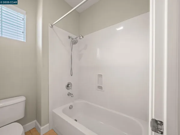 a white bath tub sitting next to a white toilet and a shower