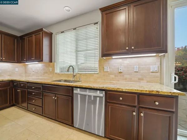 a kitchen with granite countertop cabinets sink and window