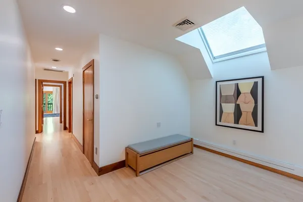 a view of a hallway with wooden floor and stairs