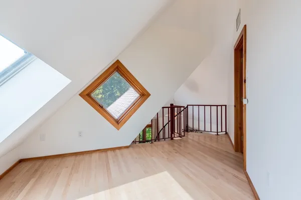 a view of a hallway with wooden floor and stairs