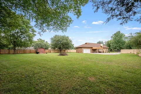 a view of a house with a yard and trees
