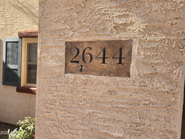 a sign that is on the side of a brick wall