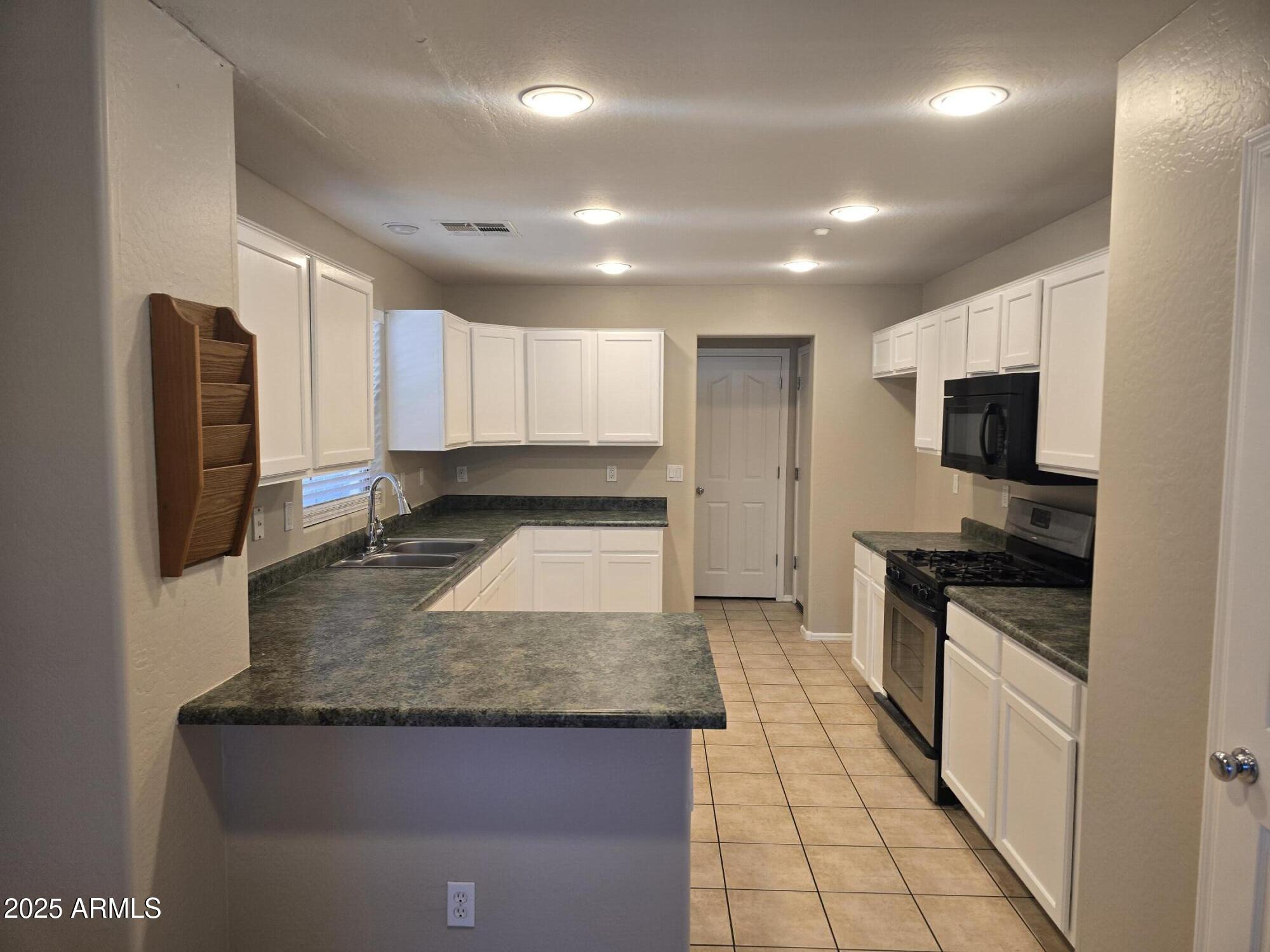 2644 East Megan Street Gilbert, AZ 85295 - Photo 2 of 21 a large kitchen with granite countertop a large counter top stainless steel appliances and cabinets