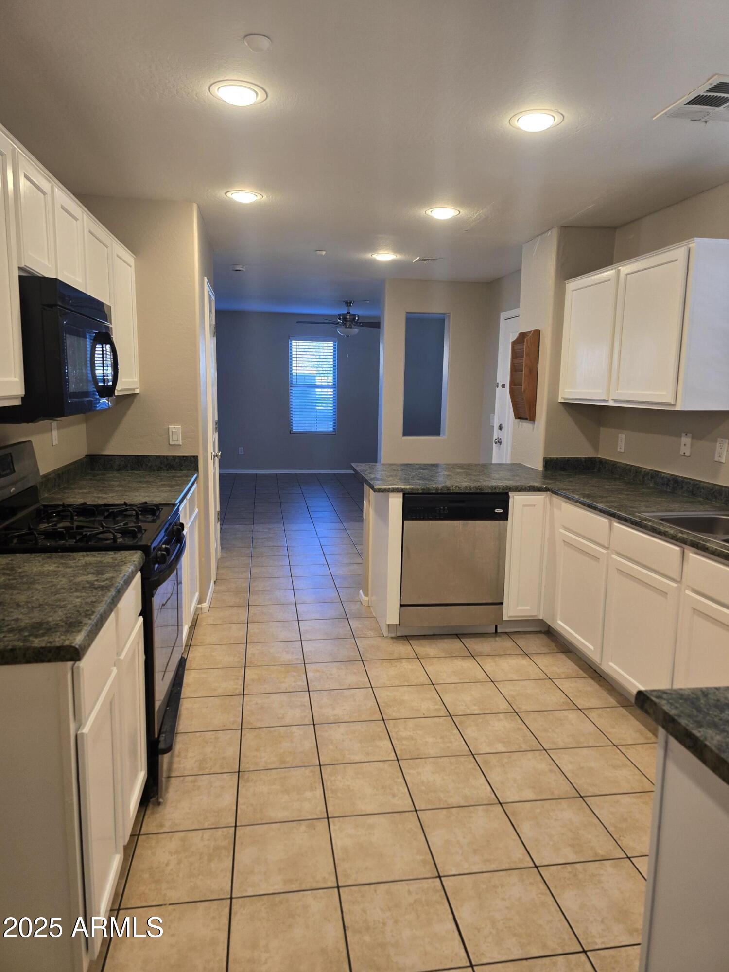 2644 East Megan Street Gilbert, AZ 85295 - Photo 3 of 21 a kitchen with stainless steel appliances granite countertop a stove a sink and a microwave
