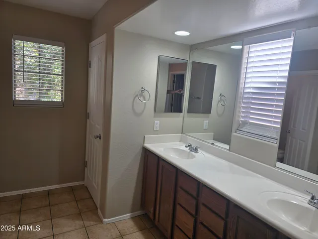 a bathroom with a sink a mirror and a window