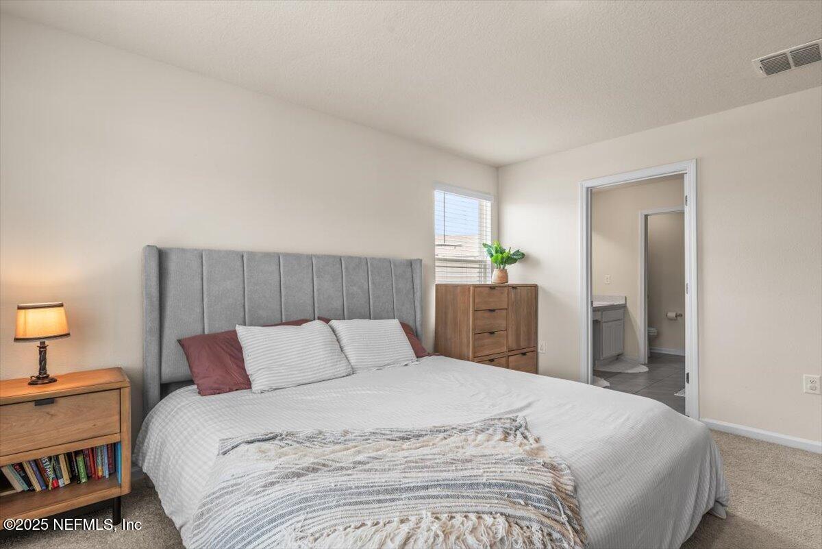 164 Java Lane St. Augustine, FL 32092 - Photo 19 of 57 a bedroom with a bed and a lamp