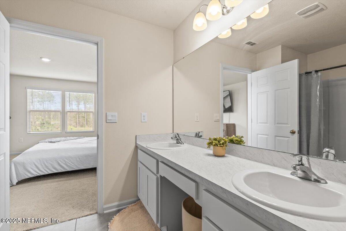 164 Java Lane St. Augustine, FL 32092 - Photo 23 of 57 a en suite bathroom with a double vanity sink and a mirror