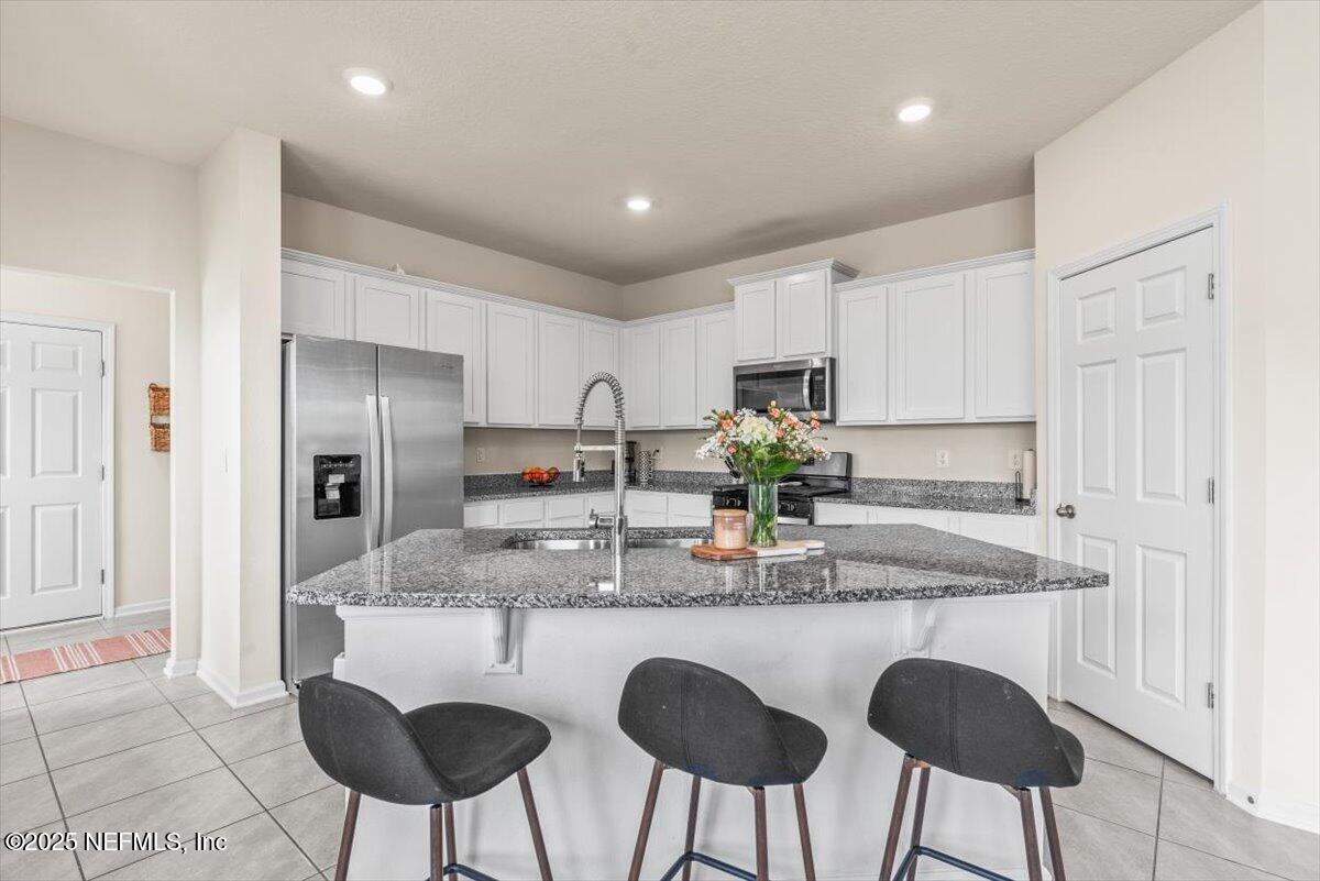 164 Java Lane St. Augustine, FL 32092 - Photo 4 of 57 a kitchen with granite countertop white cabinets and stainless steel appliances