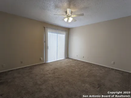 an empty room with a ceiling fan and a window