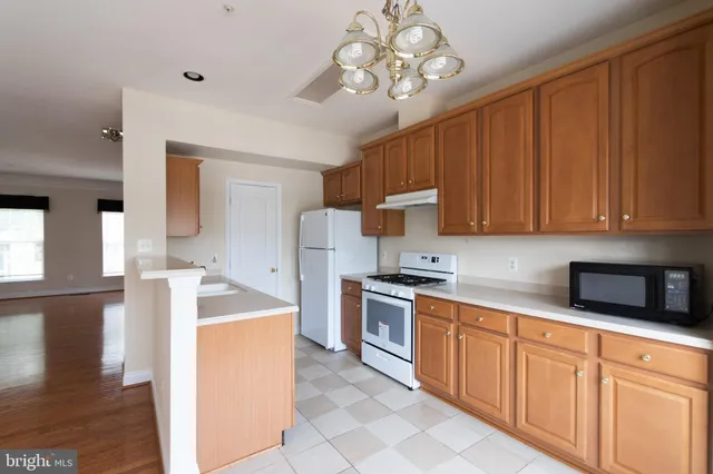 a kitchen with stainless steel appliances granite countertop a sink dishwasher stove top oven and cabinets with wooden floor