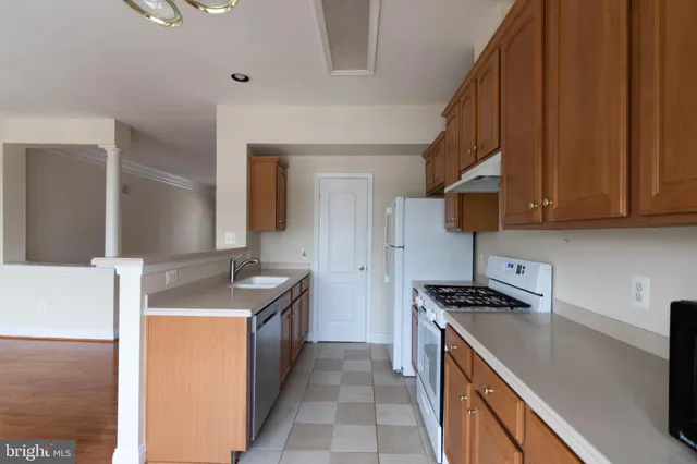 a kitchen with granite countertop a sink a stove and a refrigerator