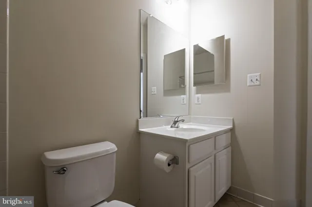 a bathroom with a toilet sink and mirror
