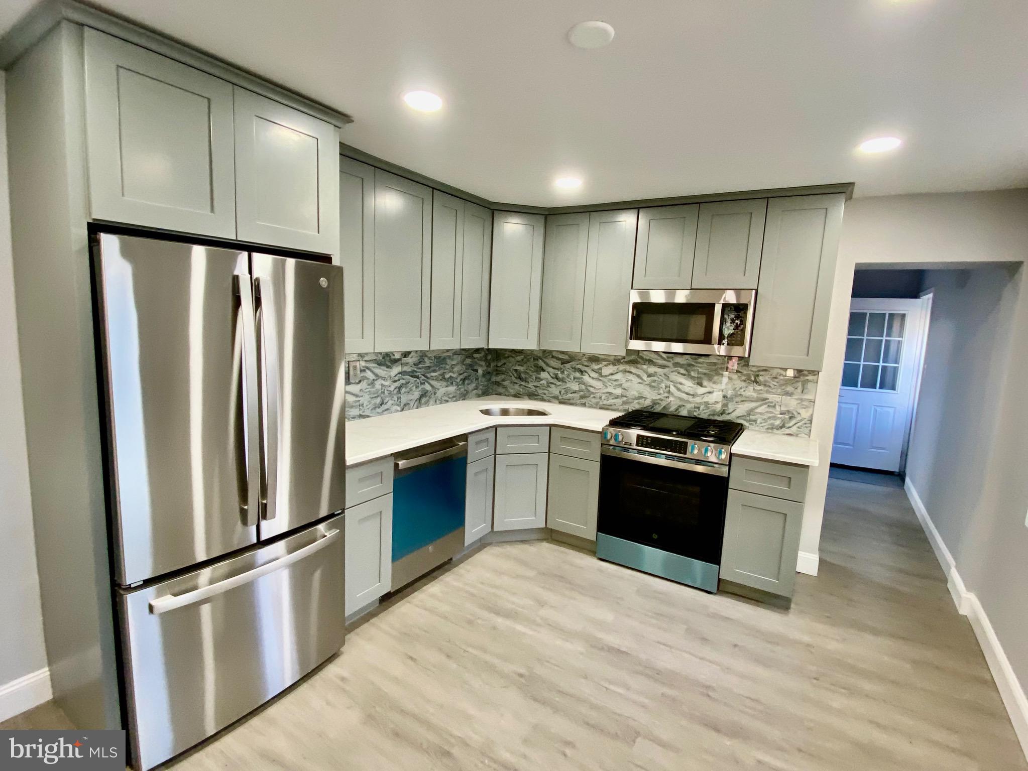 a kitchen with stainless steel appliances granite countertop a refrigerator stove a sink and dishwasher