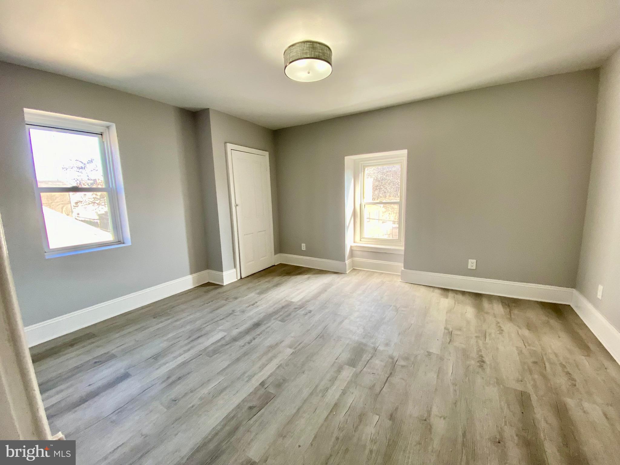 4404 Leiper Street Philadelphia, PA 19124 - Photo 12 of 14 an empty room with wooden floor and windows