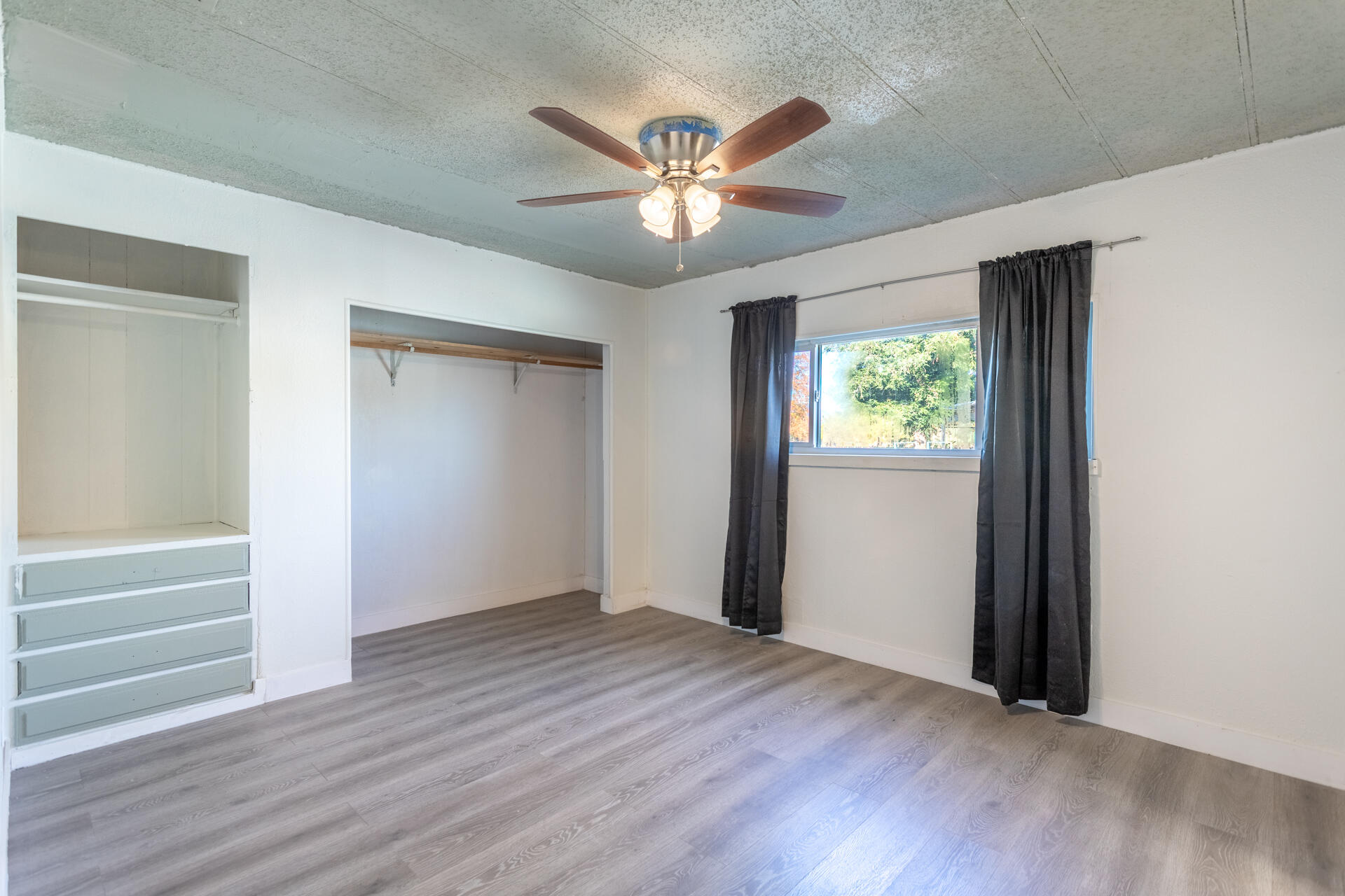 11037 Erickson Way, Unit 76 Redding, CA 96003 - Photo 7 of 13 a view of an empty room with wooden floor and a ceiling fan