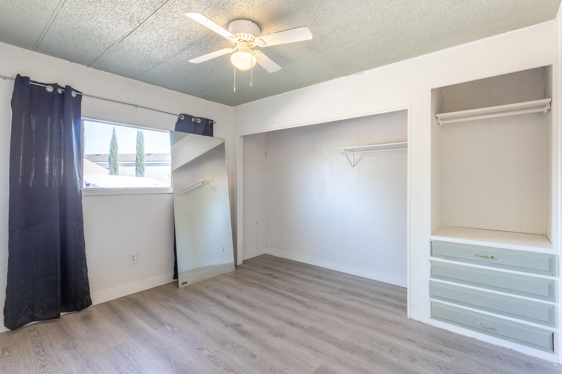 11037 Erickson Way, Unit 76 Redding, CA 96003 - Photo 9 of 13 wooden floor in an empty room with a window