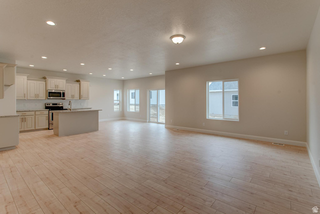 1512 West 600 North, Unit O4A Mapleton, UT 84664 - Photo 2 of 24 Unfurnished living room with recessed lighting, light wood-style floors, and healthy amount of natural light