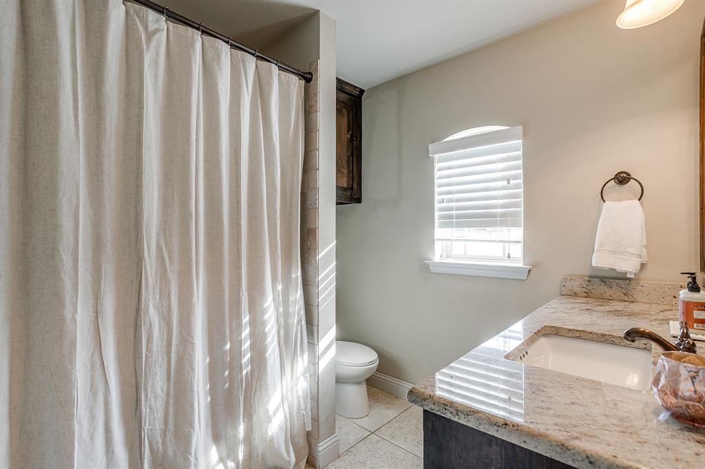 7320 Spring Ranch Court Godley, TX 76044 - Photo 35 of 40 a bathroom with a granite countertop sink and a toilet