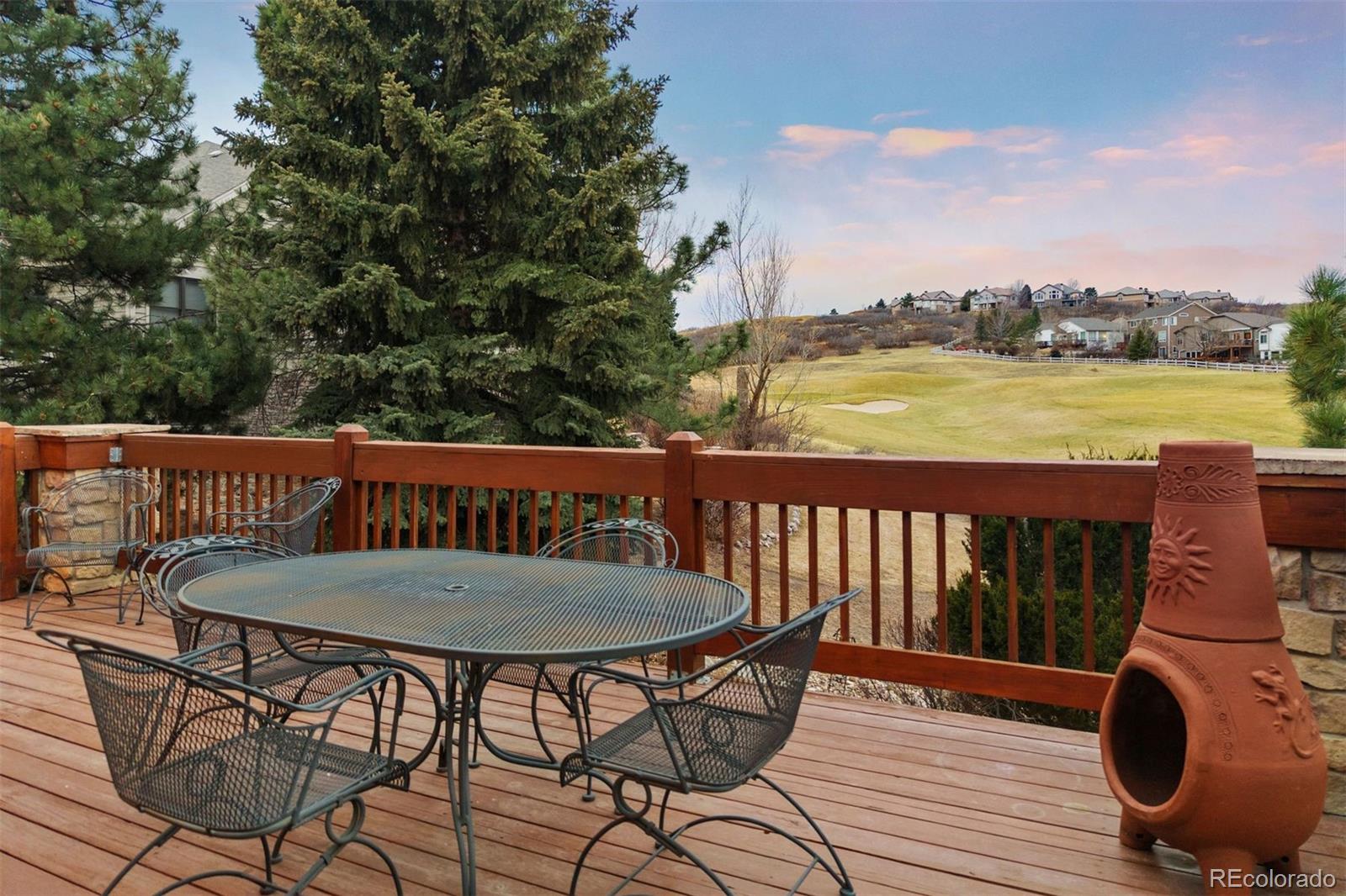10 Roder Gate Lane Castle Pines, CO 80108 - Photo 2 of 32 a balcony with wooden floor table and chairs