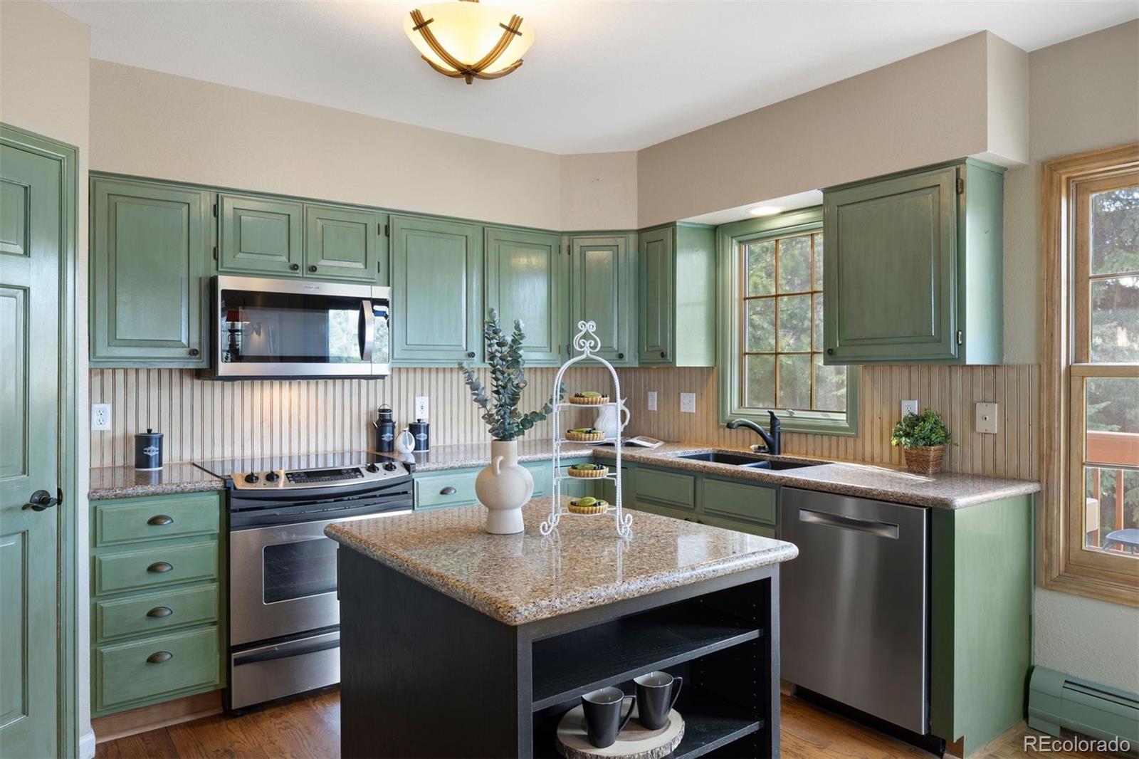 10 Roder Gate Lane Castle Pines, CO 80108 - Photo 6 of 32 a kitchen with a sink stove and microwave